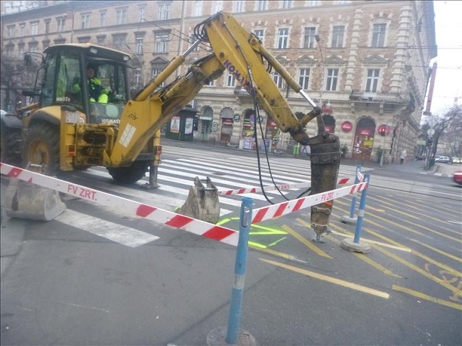 A képen egy munkagép éppen a betont töri fel.