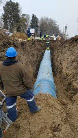 Két szakember a lefektetett 1200 mm átmérőjű csövet ellenőrzi a képen.