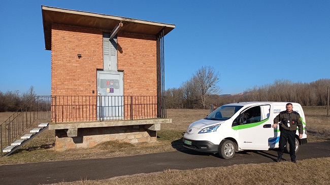 Az FV. Zrt. egyik életet mentő biztonsági őre látható a képen a társaság autója mellett.