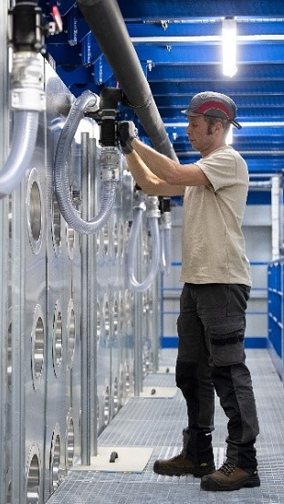 The picture depicts a blue collar worker working inside a building.