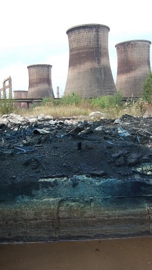 A képen egy atomerőmű, illetve a közelében ásott gödör látható. 