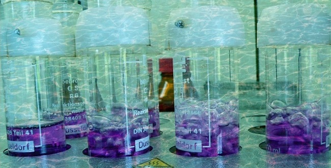 A képen kémcsövekben tárolt lila színű vegyi anyag látható. 