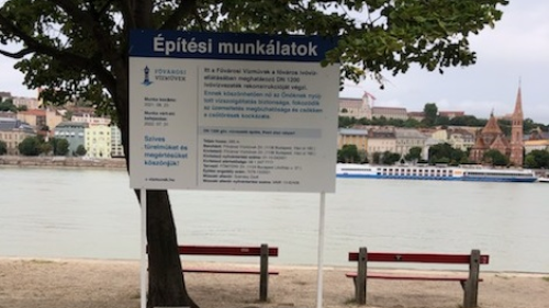 A képen a rakparton felállított, építkezési munkálatokról szóló tájékoztató plakát látható.